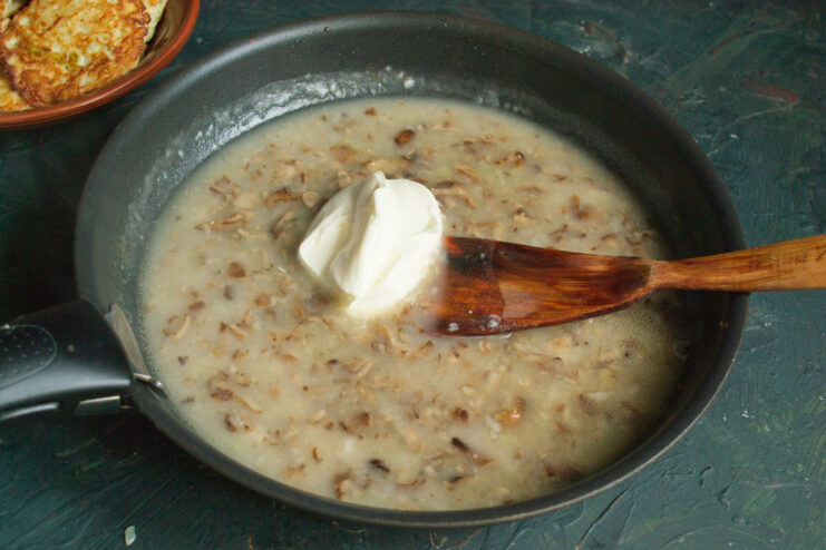 Adding the creamy element Stirring sour cream into the simmering mushroom sauce
