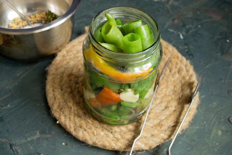 Packing the jar Packing blanched chili peppers and garlic slices tightly into a glass jar