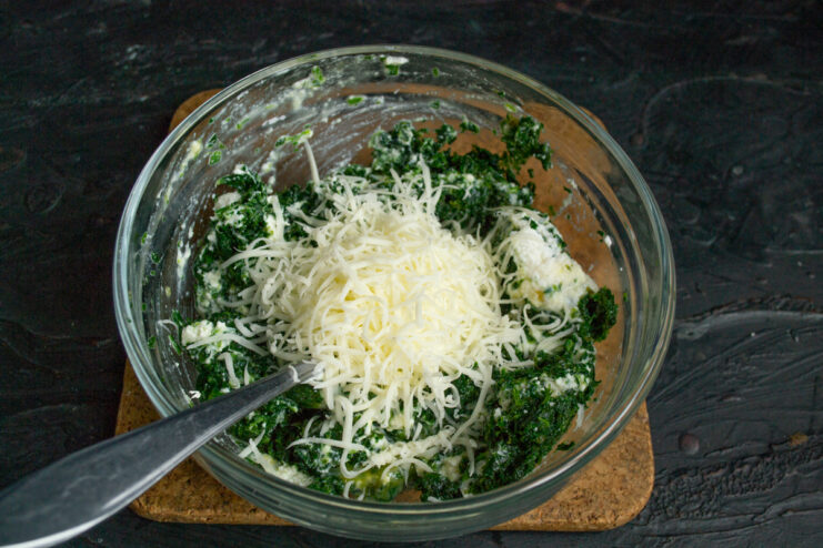 Adding finely grated suluguni cheese to the spinach base