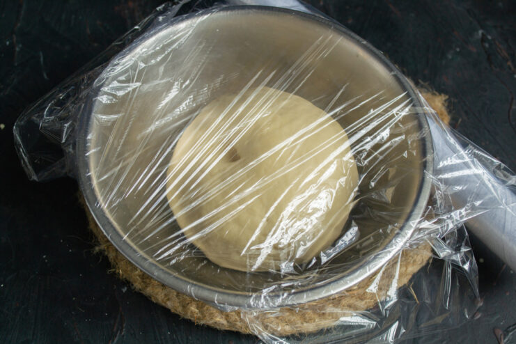 Resting the dough in the refrigerator Dumpling dough resting in a metal bowl covered with plastic wrap
