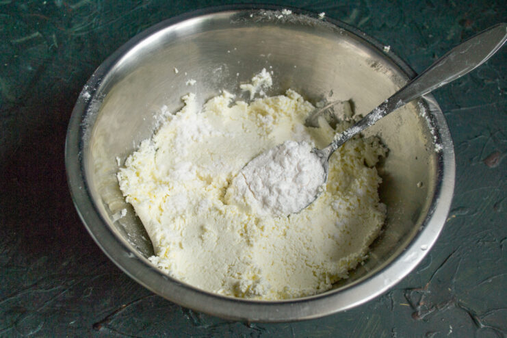Preparing the Cheese Filling Farmer's cheese mixed with powdered sugar inside a metal mixing bowl