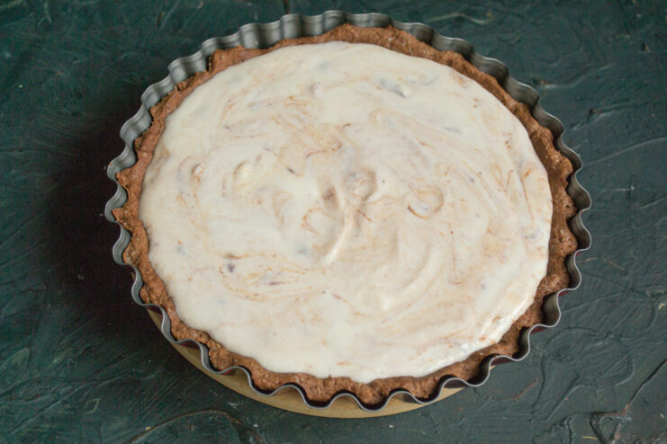 Assembling the Cheesecake Creamy cheese filling poured into the baked chocolate crust inside the pan