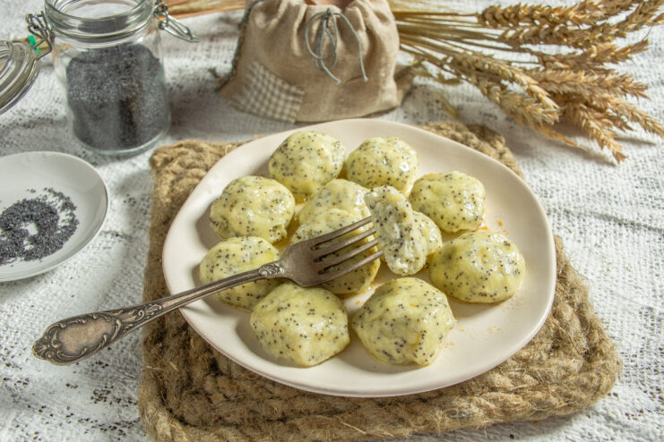 Steamed tvorog dumplings with poppy seeds and butter on a plate
