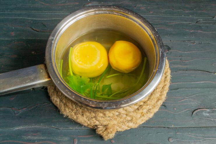 Boiling turnips in a pot of water with fresh herbs