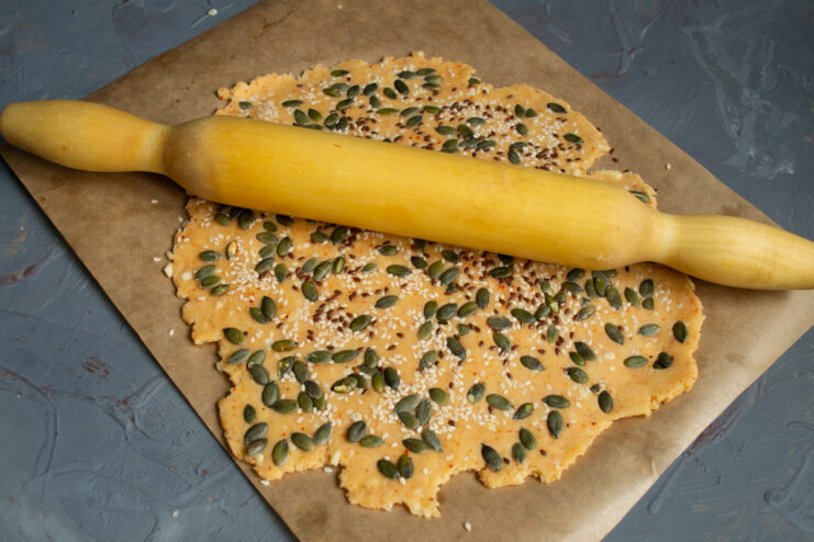 Pressing the topping Pressing flaxseeds and other toppings into the dough with a rolling pin