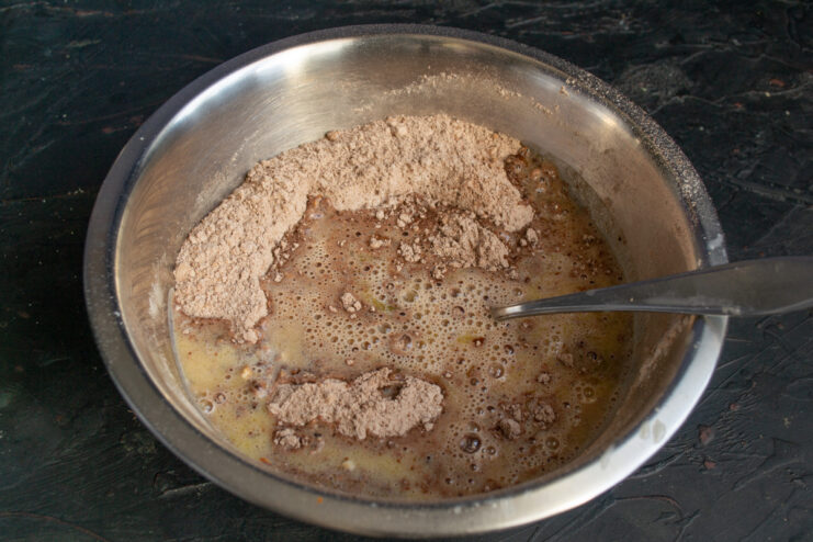 Combining Wet and Dry Ingredients Pouring warm milk and melted butter into the dry chocolate ingredients