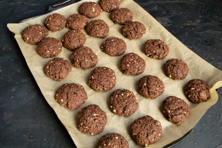 Freshly Baked Cookies Baked chocolate cookies resting on parchment paper after the oven
