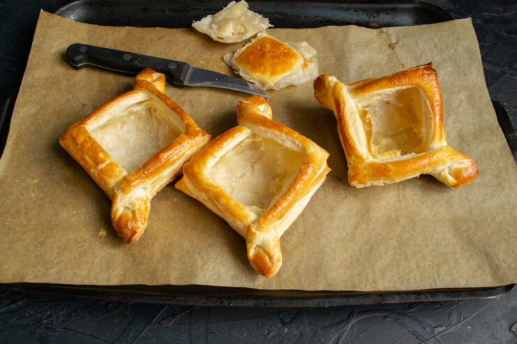 Using a sharp knife to cut out the center of a baked puff pastry