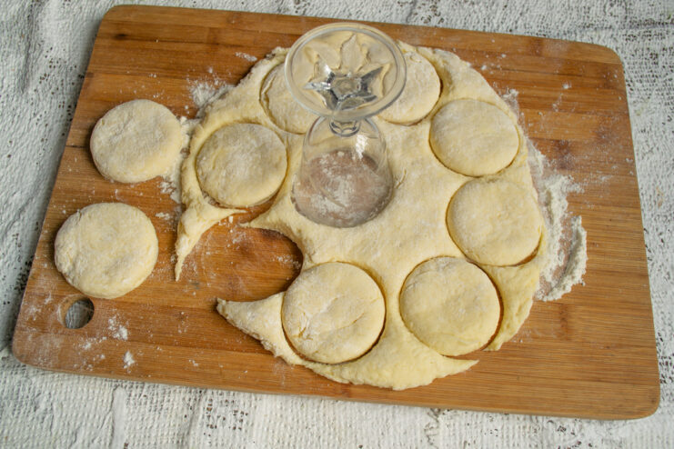 Cutting cookies with a glass Cutting out round cookie shapes from the dough using a glass