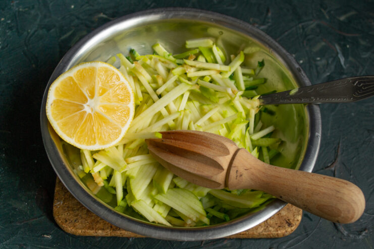 Squeezing fresh lemon juice over the julienned green apple