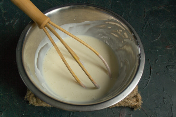 Whisking the cream Smooth whisked sour cream and condensed milk mixture in a bowl