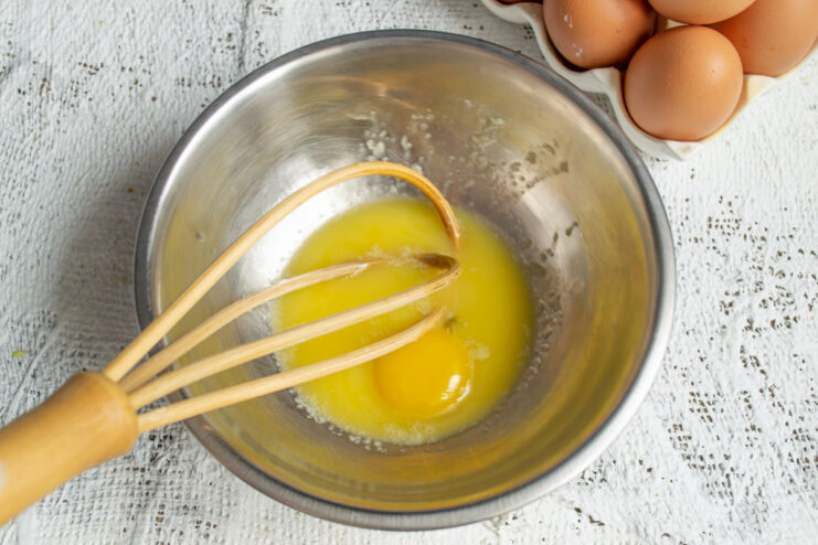 Beating the Egg Yolks Egg yolks and sugar whisked together in a metal mixing bowl.