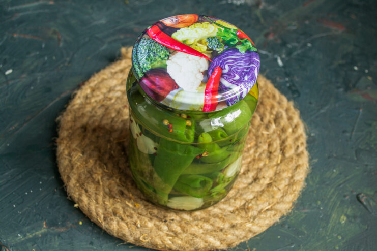 Sealing the jar Tightly screwing a metal lid onto a jar of marinated chili peppers