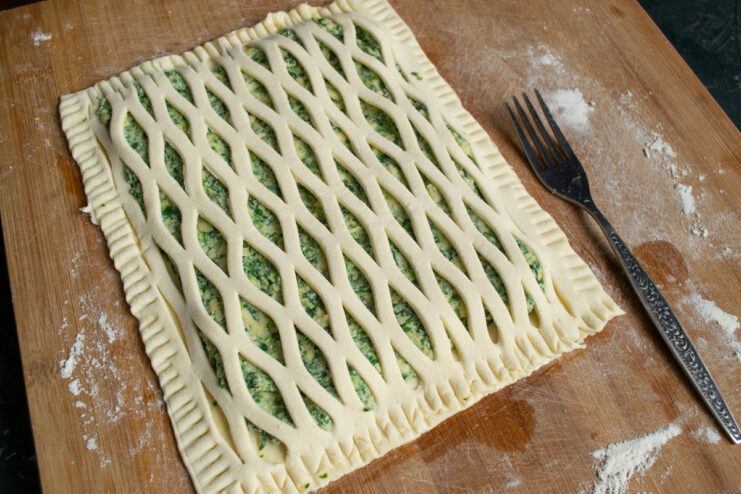 Crimping the pastry edges Crimping the edges of the puff pastry tart with a fork