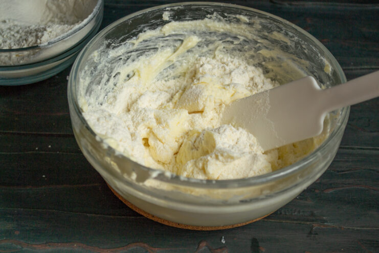 Starting the dough Folding dough with a spatula in a clear bowl