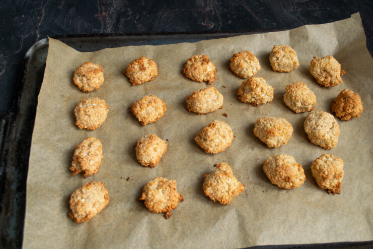Baked golden cookies on a parchment-lined baking tray