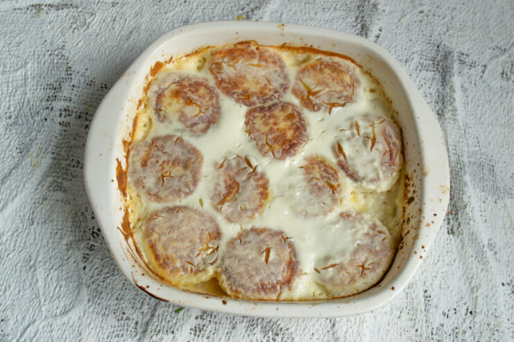 Freshly Baked Syrniki Baked syrniki with a golden crust in an oven-safe dish
