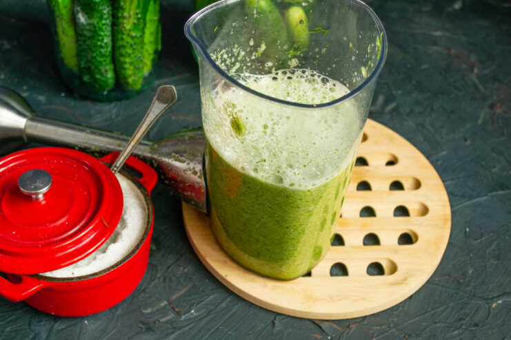 Blending the green brine Smooth green vegetable and herb brine mixed inside a blender jar