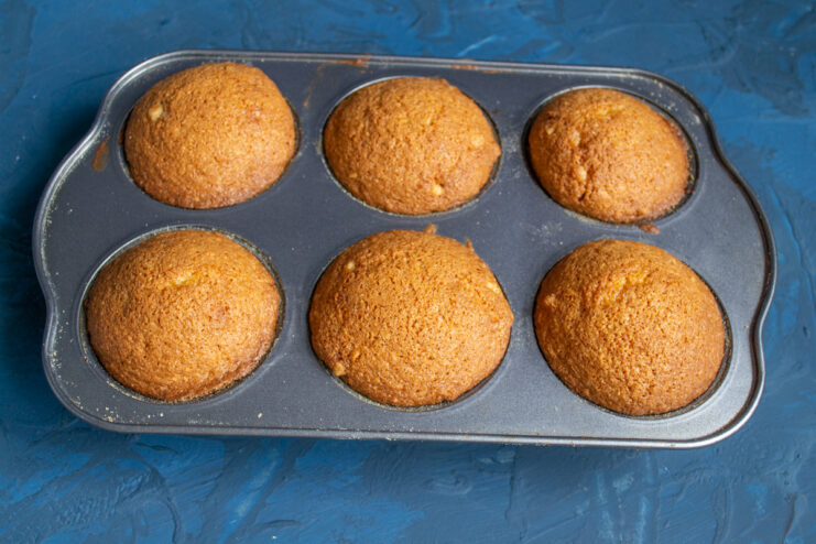 Baked muffins Freshly baked golden muffins in a tin straight from the oven.