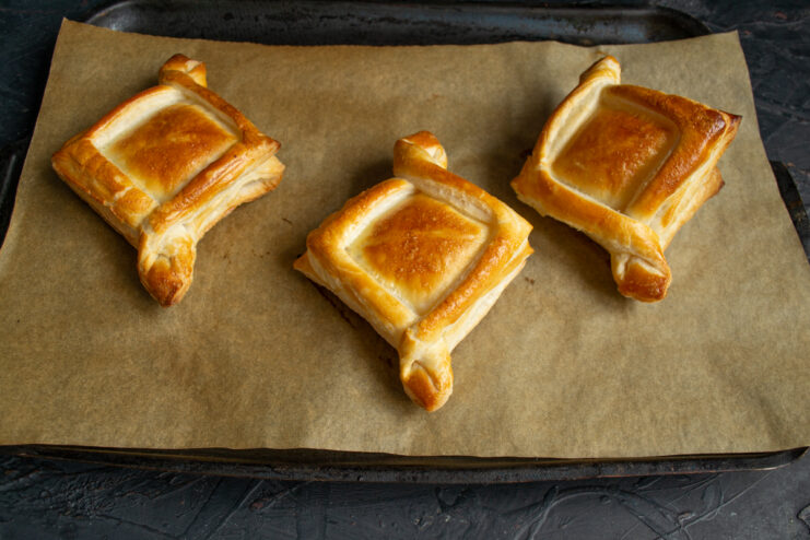 Golden brown baked puff pastry shells on a baking sheet