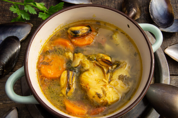 Appetizing cod and mussel soup served in a rustic ceramic bowl