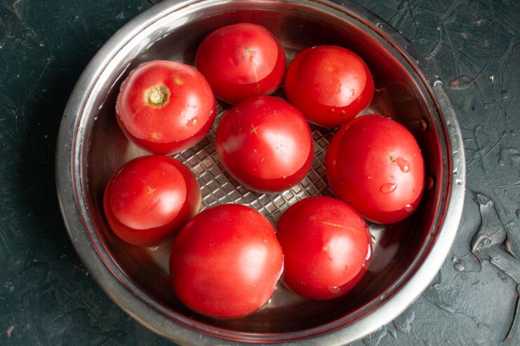 Blanching tomatoes to remove the skins Blanching fresh red tomatoes in a pot of boiling water