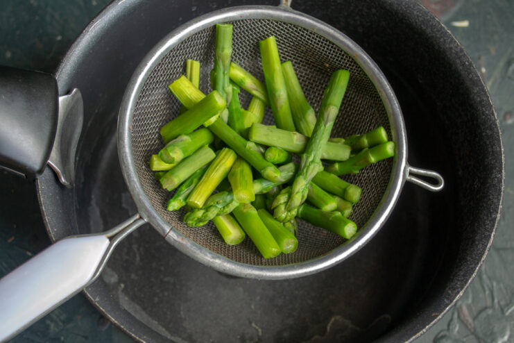 Cooking The Asparagus Blanched asparagus resting in a metal sieve