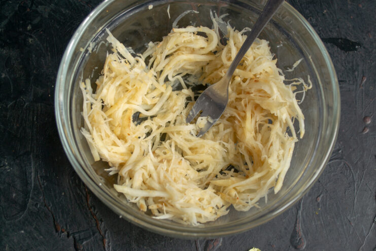 Placing celeriac into a bowl Blanched and cooled celeriac strips in a glass salad bowl