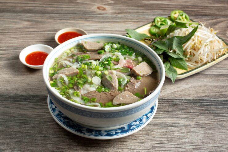 Classic bowl of beef pho bo noodle soup Large bowl of Vietnamese pho bo soup with beef slices and fresh herbs.