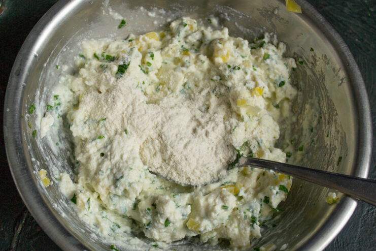 Whole wheat flour added to the bowl with cheese and vegetables