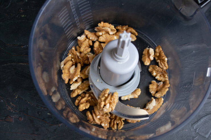 Prepping the walnuts Whole walnuts sitting in a food processor bowl ready for blending