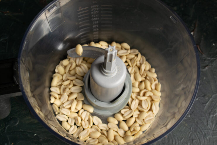 Preparing peanuts for the spread Whole blanched peanuts inside a food processor bowl