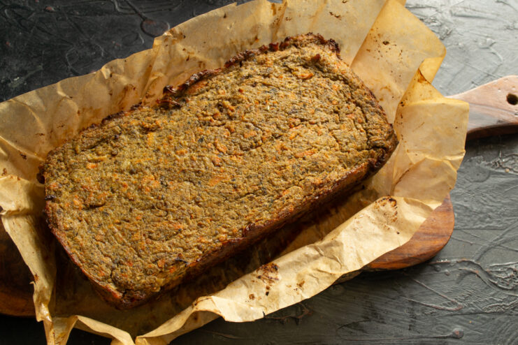 Homemade liver pate A whole rectangular loaf of homemade liver pate on a wooden board.
