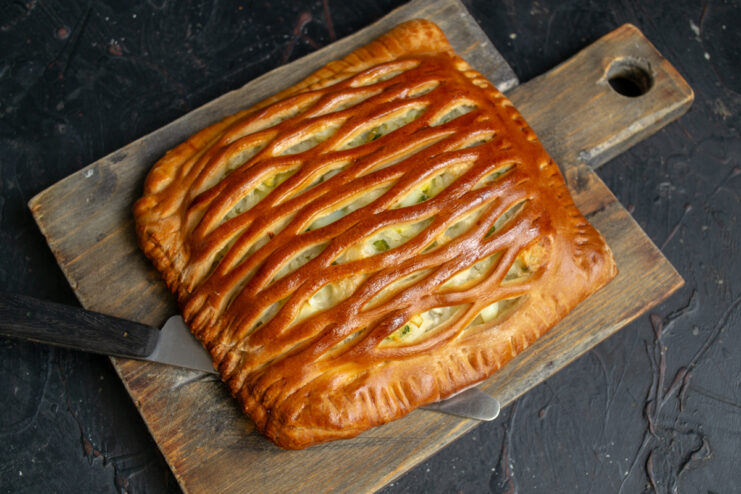 Whole freshly baked rice and egg pie on a wooden board