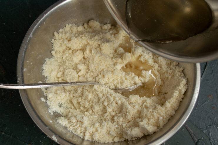 Pouring cold sugar syrup into the dry almond and sugar mixture