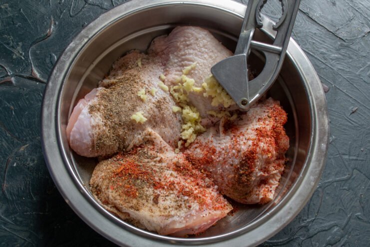 Adding Fresh Garlic Adding minced garlic to seasoned chicken thighs
