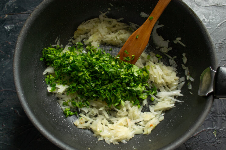Adding Parsley and Celery Adding chopped greens to the onions