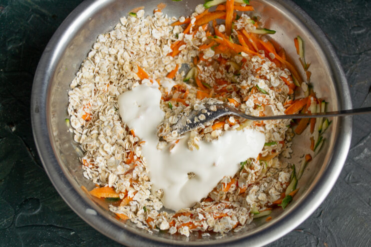 Mixing yogurt into the batter Stirring plain yogurt into the vegetable batter