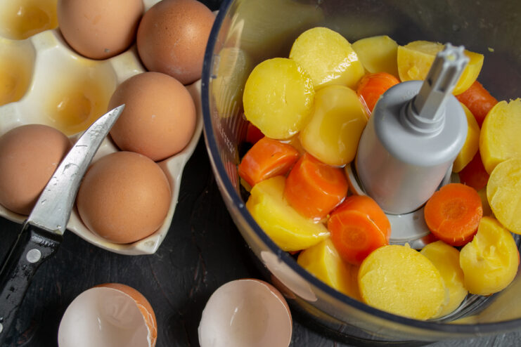 Adding Eggs To The Mix Adding chicken eggs to the vegetables in a food processor