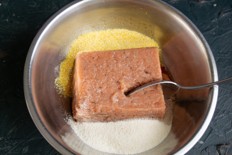 Adding semolina and polenta to ground salmon in a bowl