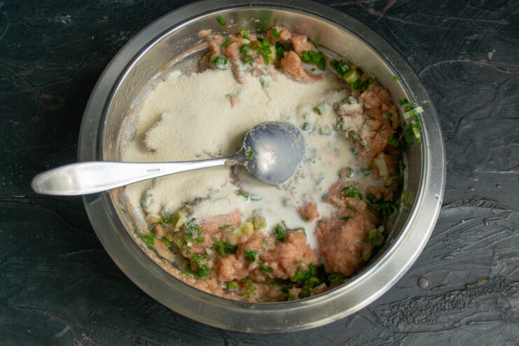 Semolina and milk Pouring milk and adding semolina to the minced fish bowl.