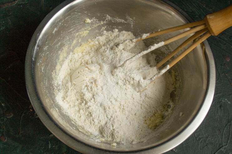 Mixing Dry Ingredients Adding flour and baking powder to dough