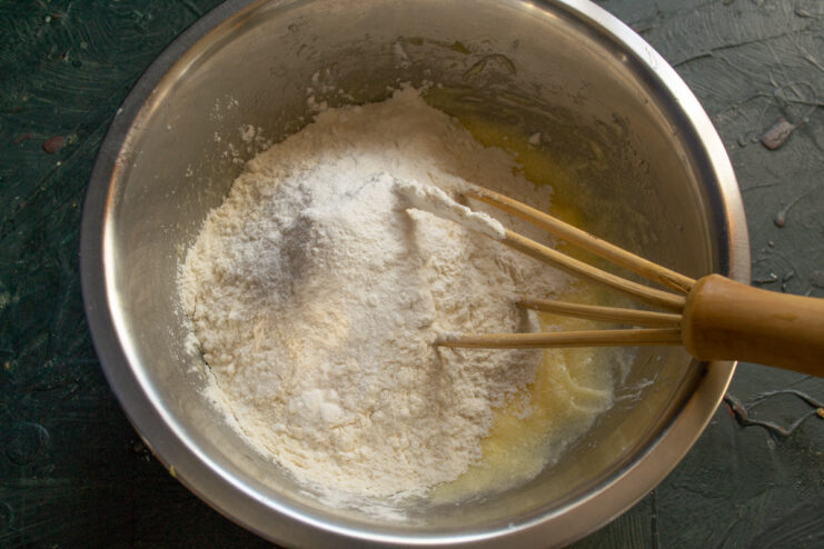 Combining dry and wet ingredients Adding flour and baking powder to the wet scone batter