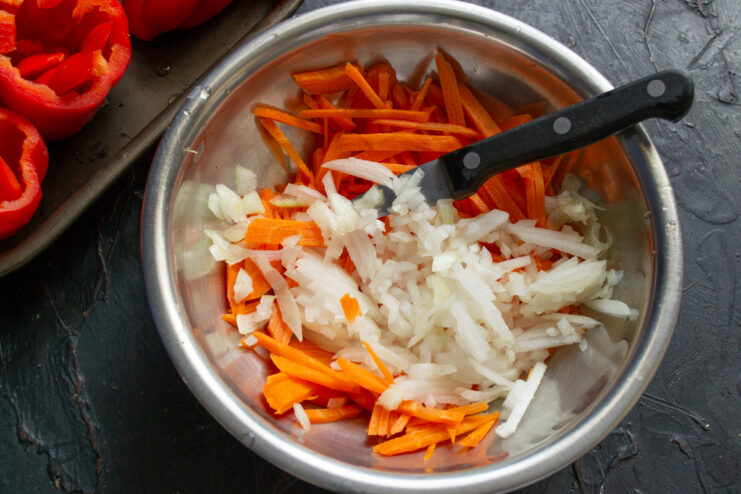 Mixing onions and carrots Adding finely diced onions to julienned carrots in a bowl