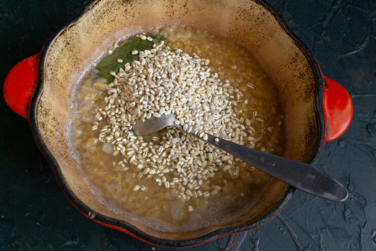 Adding Pearl Barley to the Pot Pouring pearl barley into the pot of simmering lentils
