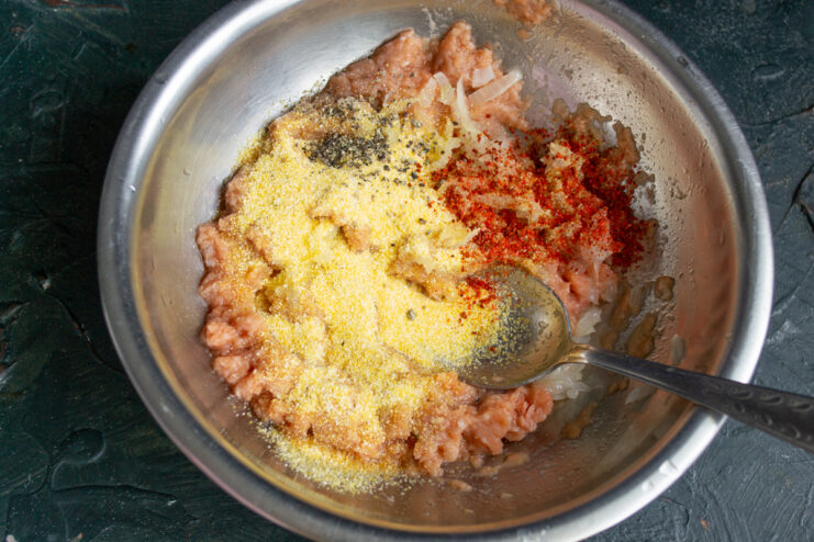Adding spices and polenta to the fish Adding corn polenta and spices to the minced fish