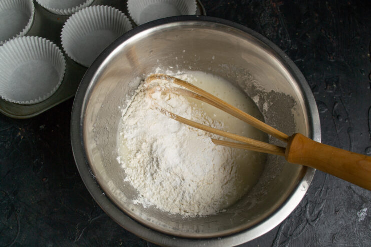 Sifting all-purpose flour into the wet batter