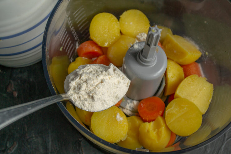 Adding Flour And Spices Spooning wheat flour into a bowl with processed vegetables
