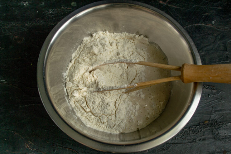 Mixing flour and starter Adding wheat flour to sourdough starter and brine