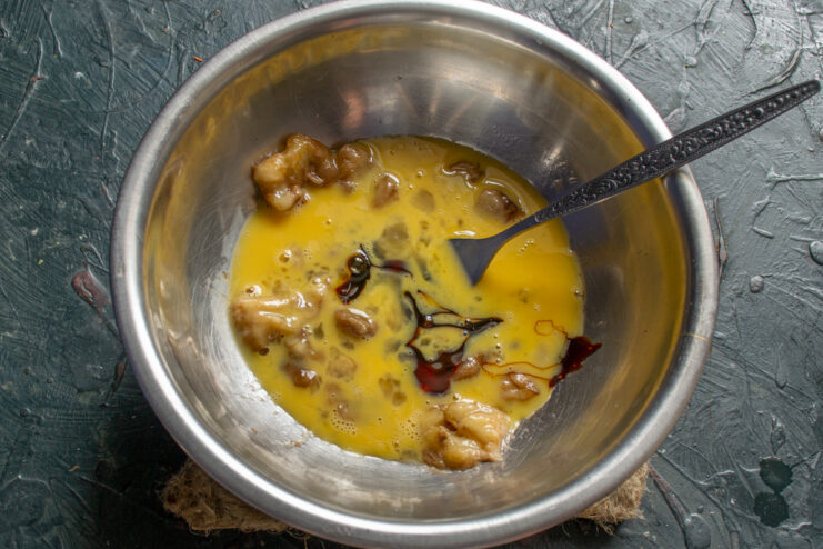 Pouring dark rye malt syrup into the banana and egg mixture